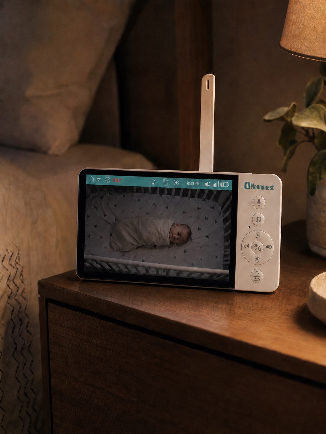 The Nonnanest handheld showing a live view of a sleeping baby with an elevated skin temperature reading highlighted.